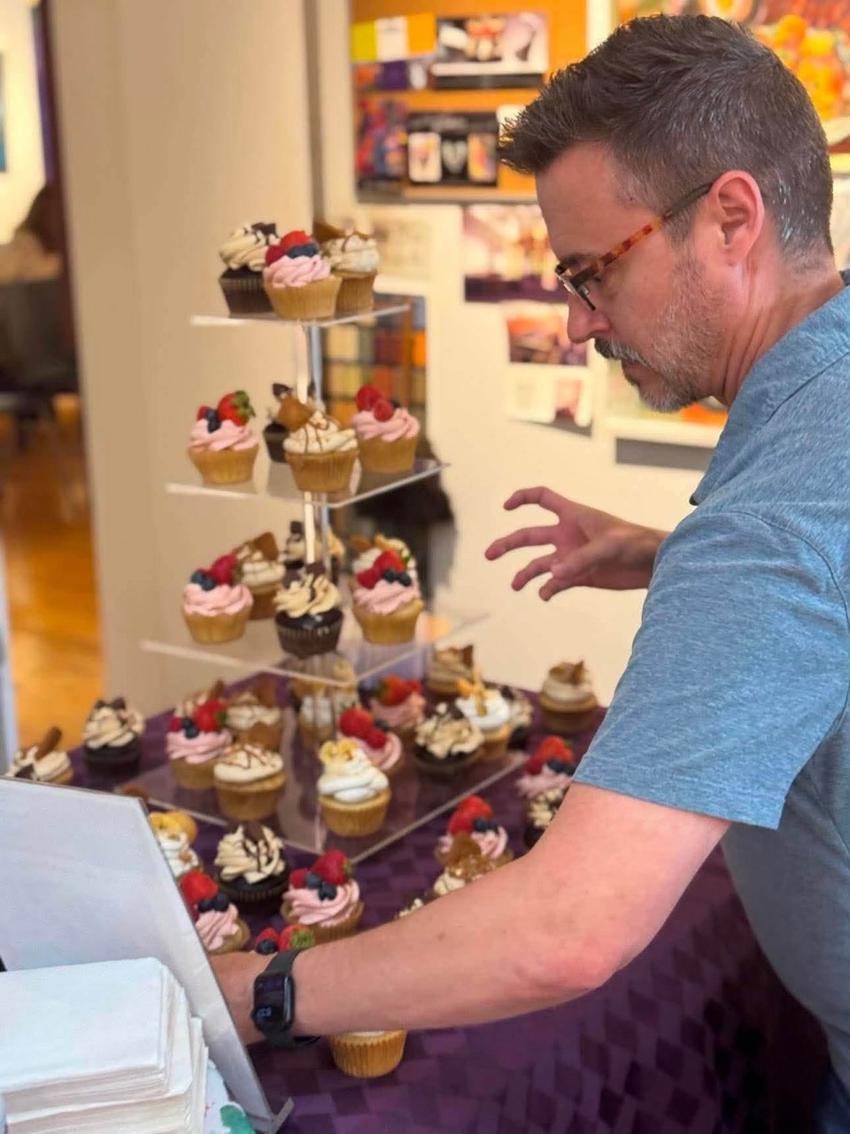 Jeremy arranging cupcakes at a dessert table