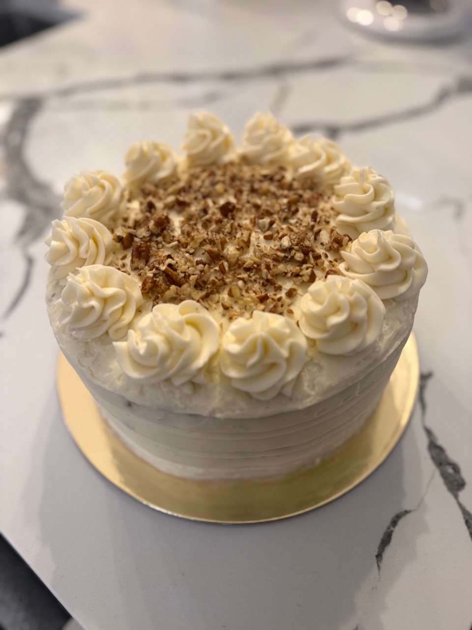 Carrot cake with piped frosting and pecans